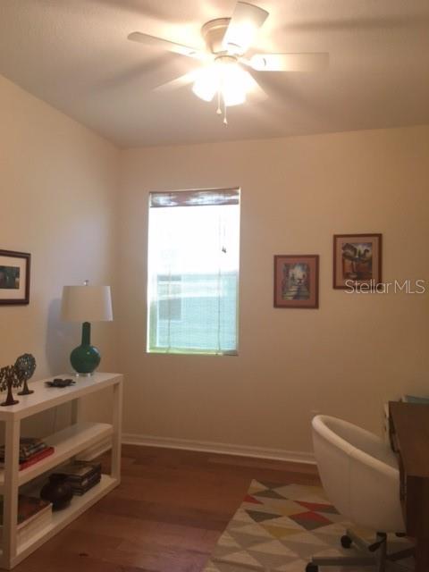 A home office features a ceiling fan, a window, a white console table, and a desk chair — 7903 PLEASANT PINE CIRCLE, WINTER PARK, FL