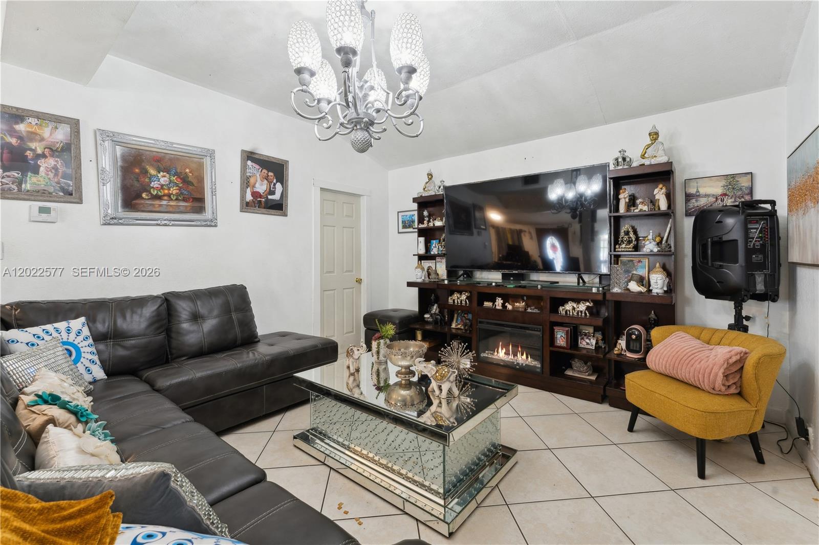 A living room features a dark leather sectional, mirrored coffee table, and a large media console — MIAMI, FL