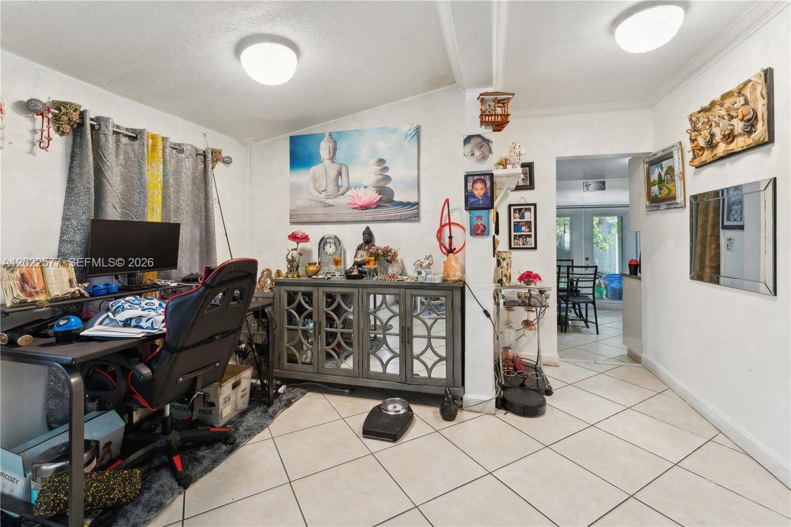 A room with a desk, a mirrored cabinet, tiled floors, and wall decor — MIAMI, FL