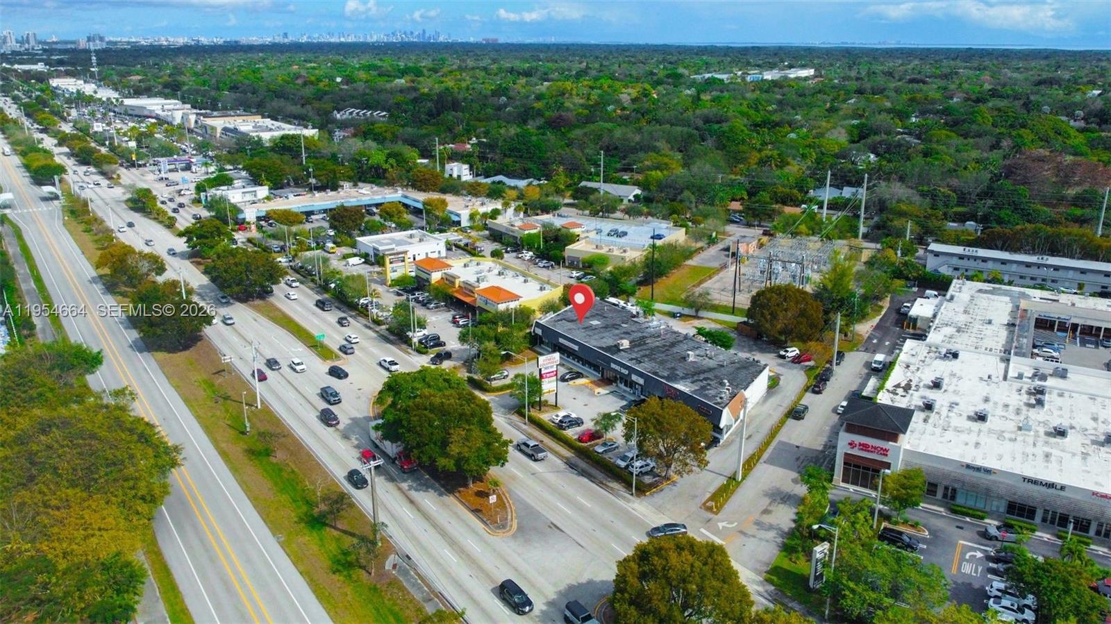 An aerial view shows a commercial building with a parking lot along a busy road — 12253 S Dixie Hwy, Pinecrest FL 33156, PINECREST, FL