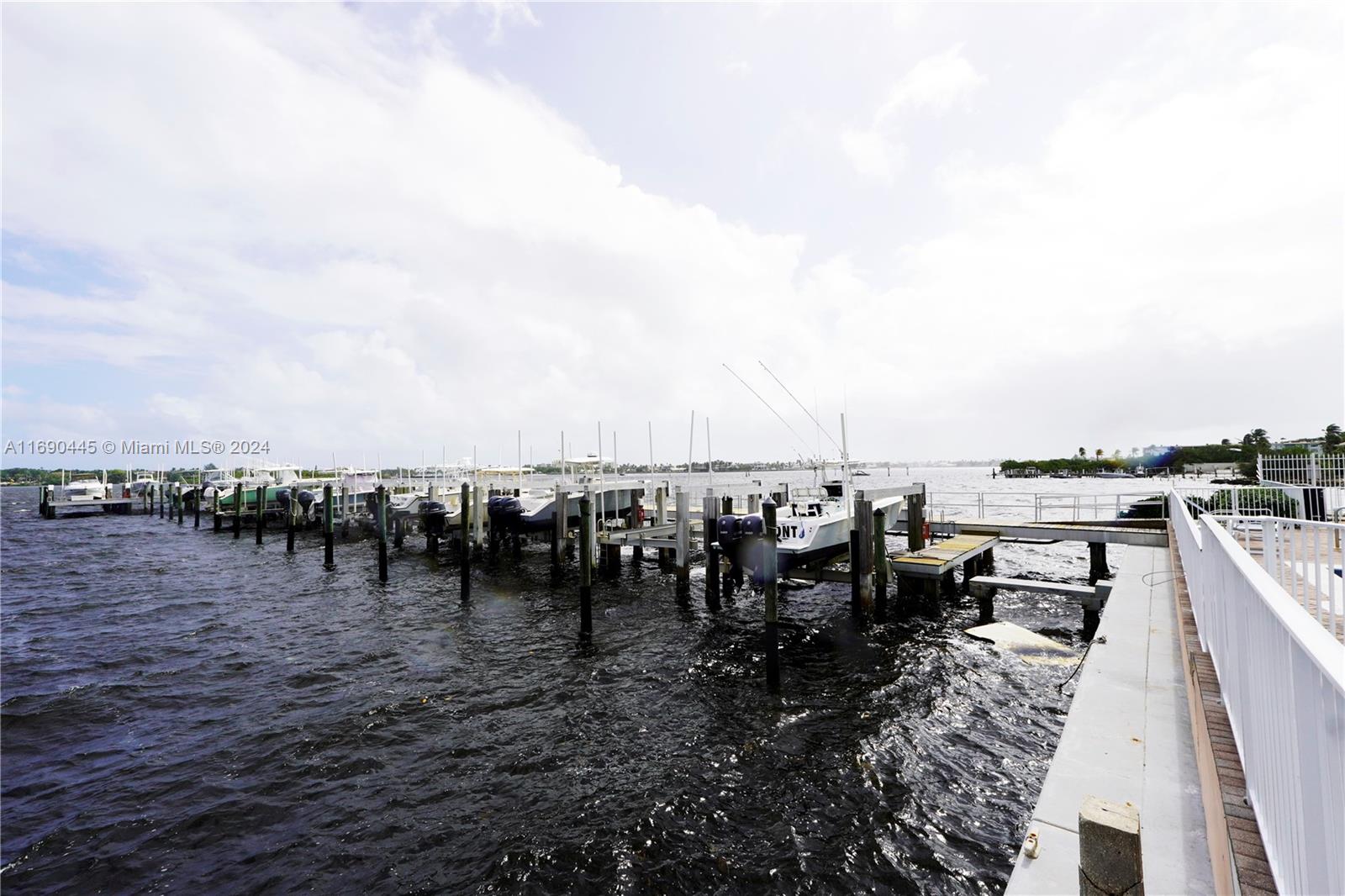 A row of boats is docked at a wooden pier extending into a large body — 123 Harbors Way, Boynton Beach FL 33435, BOYNTON BEACH, FL