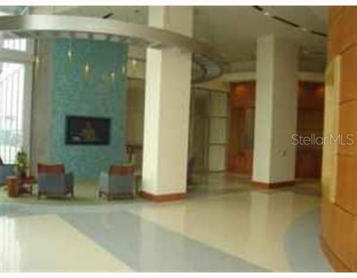 A modern lobby features a blue accent wall, two armchairs, and large white support columns — 777 N ASHLEY DRIVE UNIT 1701, TAMPA, FL