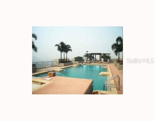 An outdoor swimming pool with a pergola and palm trees on a rooftop terrace — 777 N ASHLEY DRIVE UNIT 1701, TAMPA, FL