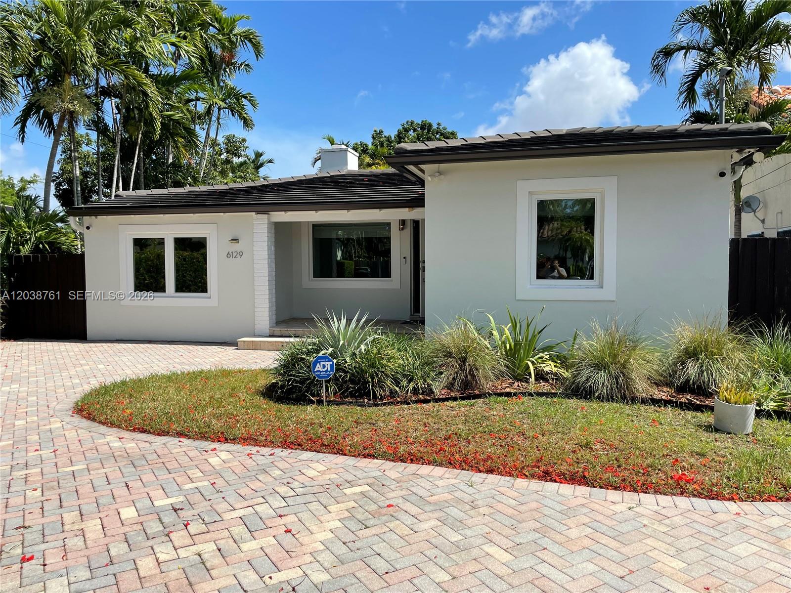 A single-story house with a paved driveway, white exterior, and a small front garden — 6129 SW 28th St, Miami FL 33155, MIAMI, FL