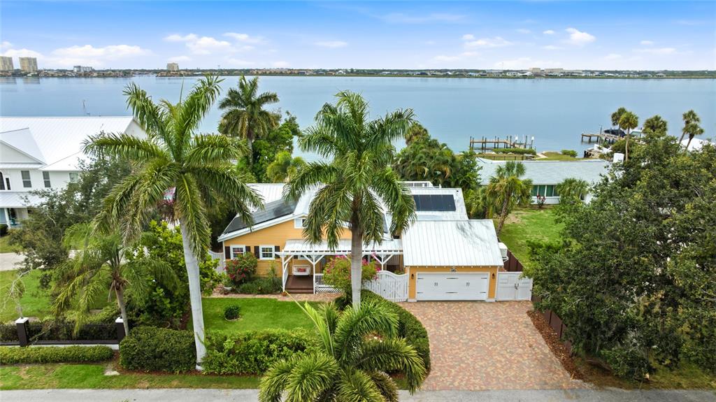 An aerial view shows a yellow house with a metal roof and a brick driveway — 1625 1ST AVENUE E, BRADENTON, FL