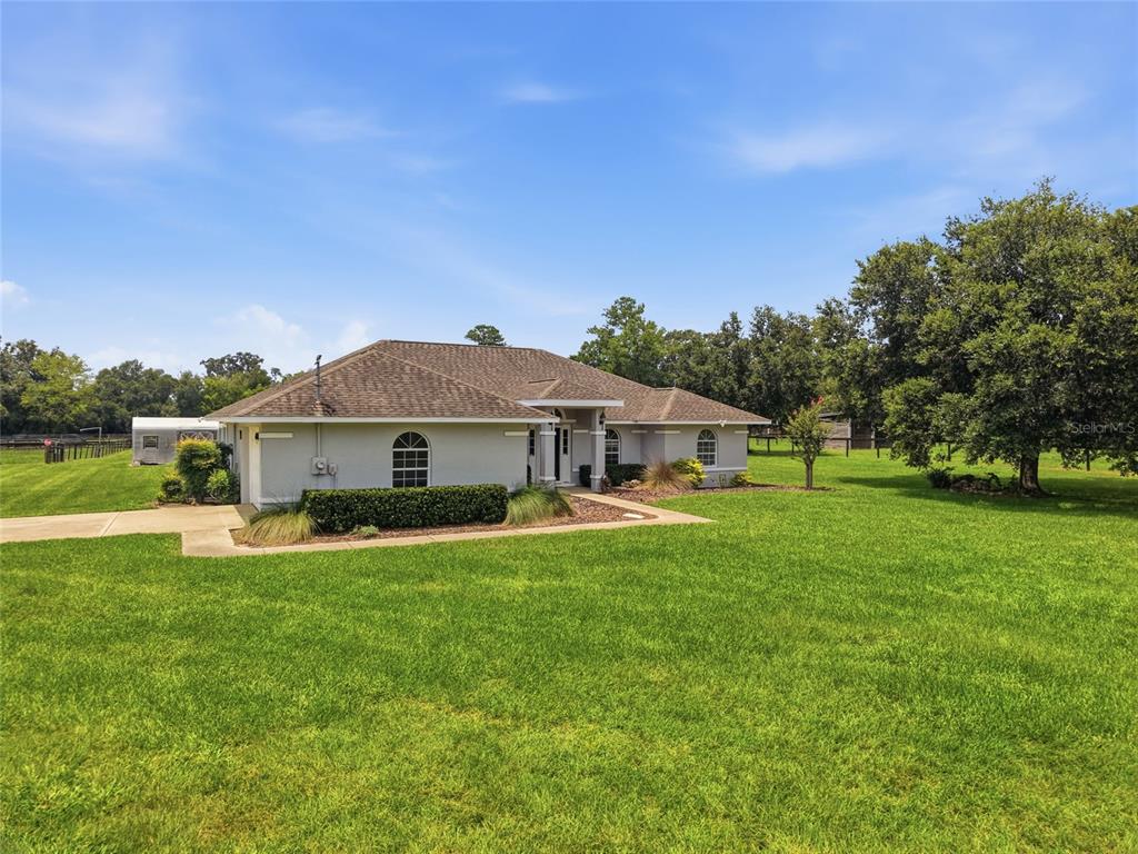 An aerial view shows a house and barn situated on a large, fenced rural property — 4698 NW 110TH AVENUE, OCALA, FL