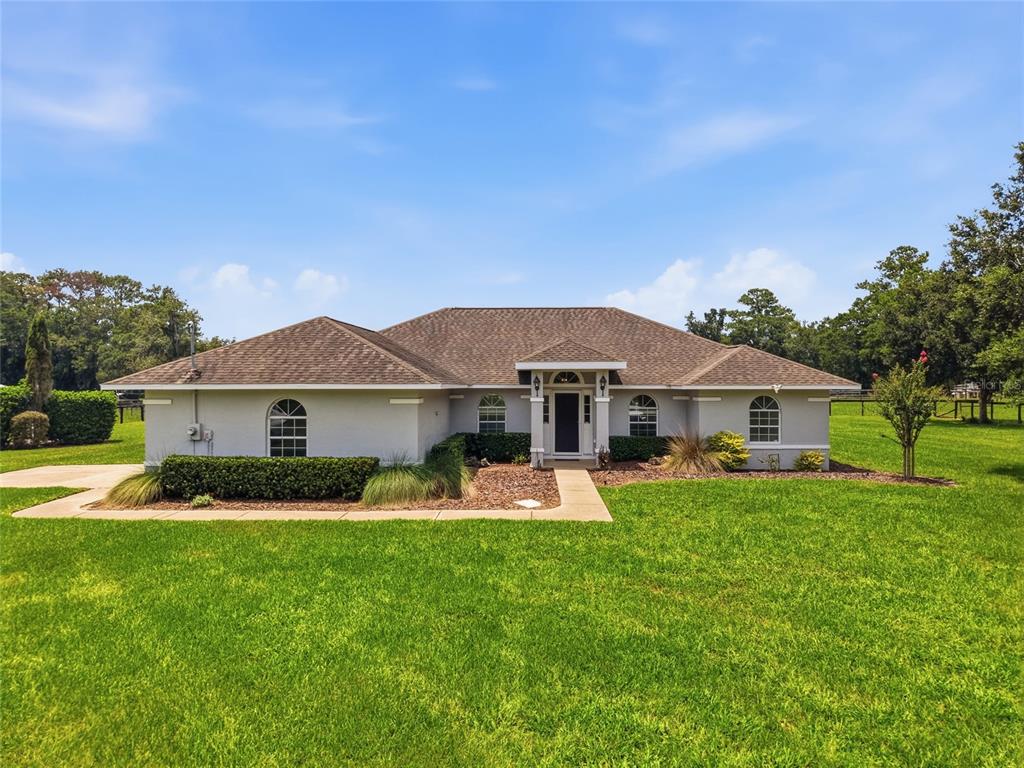 A single-story house with a light-colored exterior sits on a large, grassy lot — 4698 NW 110TH AVENUE, OCALA, FL
