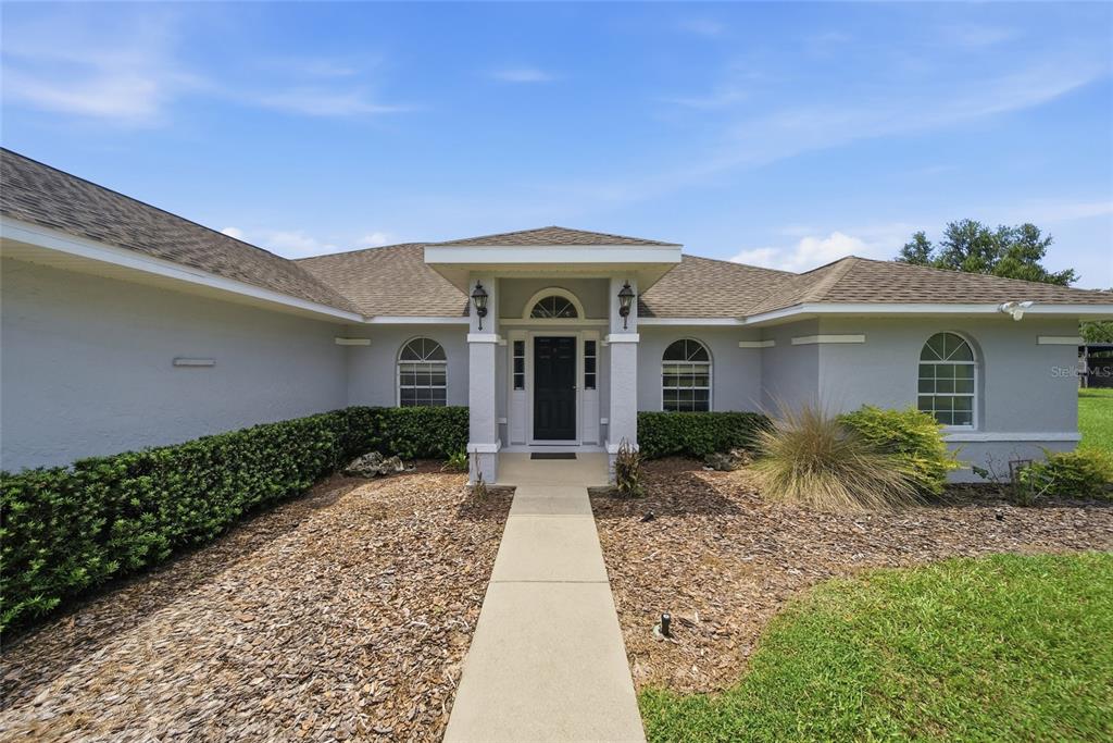 A single-story house with a hip roof sits in the middle of a large lawn — 4698 NW 110TH AVENUE, OCALA, FL
