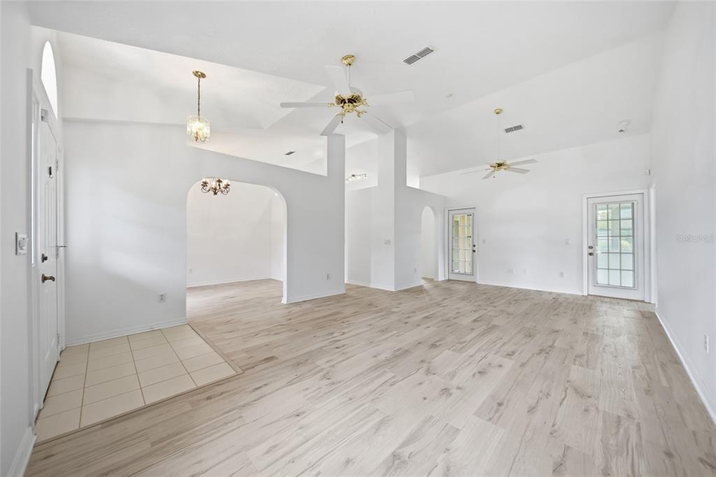 The exterior of a single-story house features a covered entryway, gray stucco walls, and landscaping — 4698 NW 110TH AVENUE, OCALA, FL