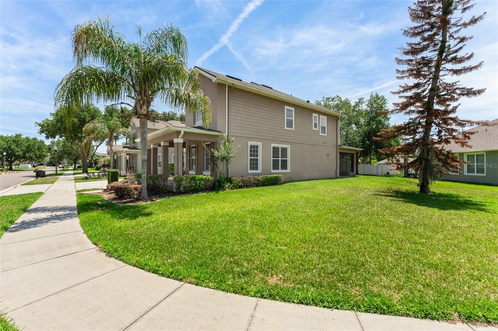 A two-story house with tan siding and a palm tree stands next to a sidewalk — 13544 RIGGS WAY, WINDERMERE, FL
