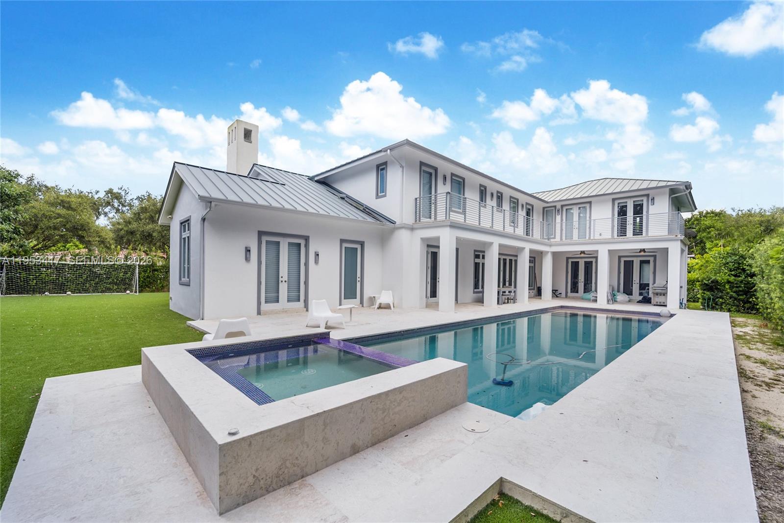 A modern entryway features a staircase, tile flooring, a console table, and double glass doors — 6900 Barquera St, Coral Gables FL 33146, CORAL GABLES, FL