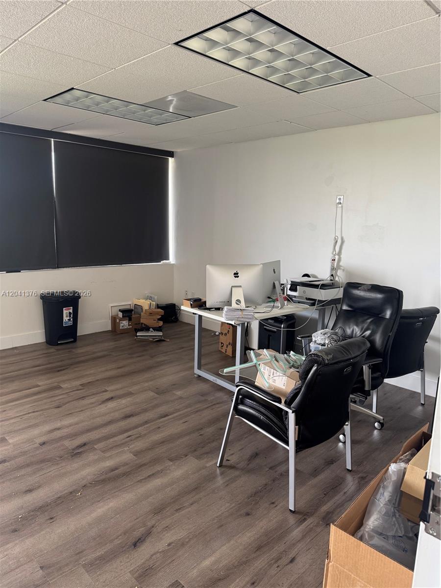An office space features wood-look flooring, drop ceiling panels, and a desk with computer equipment — 8700 W Flagler St # 408, Miami FL 33174, MIAMI, FL