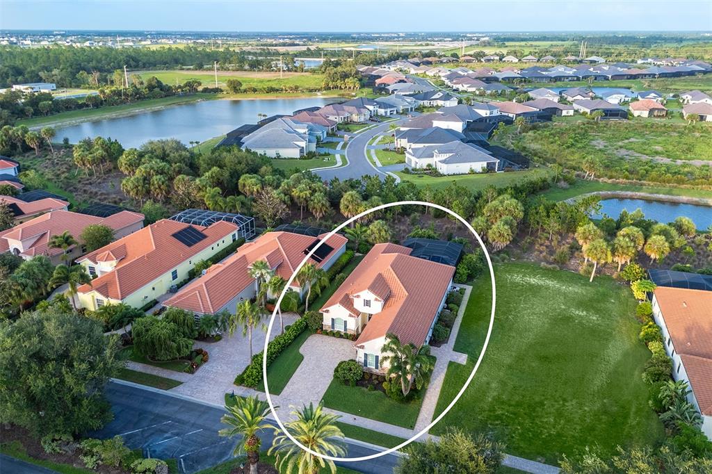 An aerial view shows a single-family house with a tiled roof and a screened pool — 1744 GRANDE PARK DRIVE, ENGLEWOOD, FL