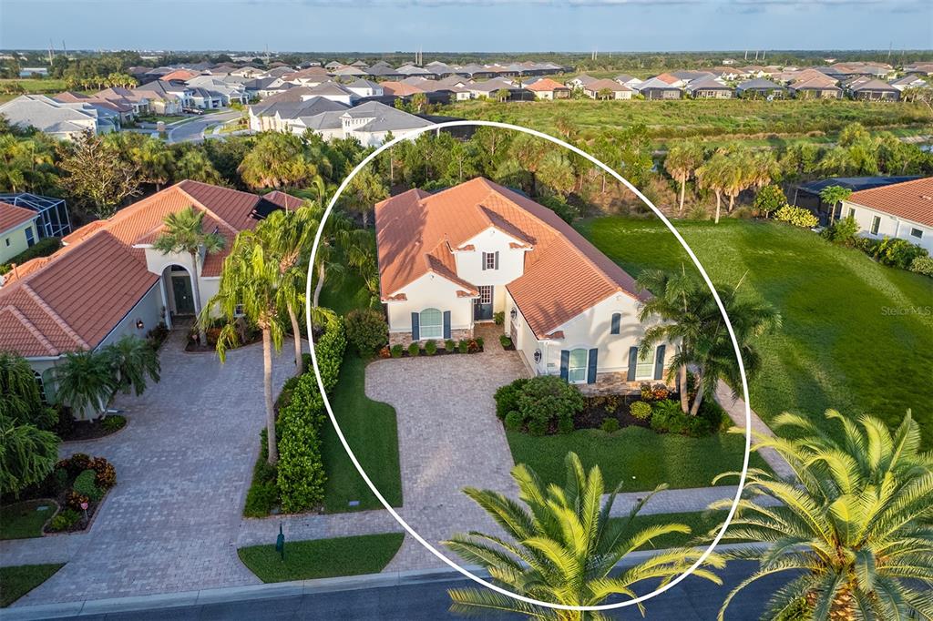 An aerial view of a single-story house with a tile roof and paved driveway — 1744 GRANDE PARK DRIVE, ENGLEWOOD, FL