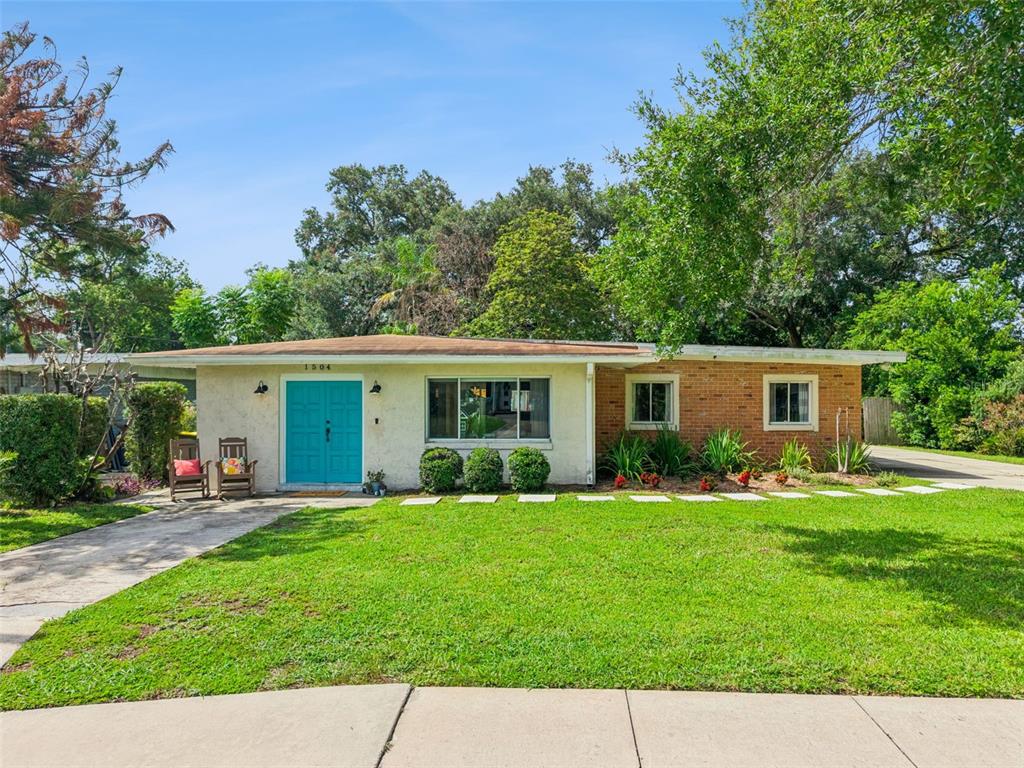 A single-story house with a brick and stucco exterior, a teal door, and a lawn — 1504 IDAHO AVENUE, ORLANDO, FL
