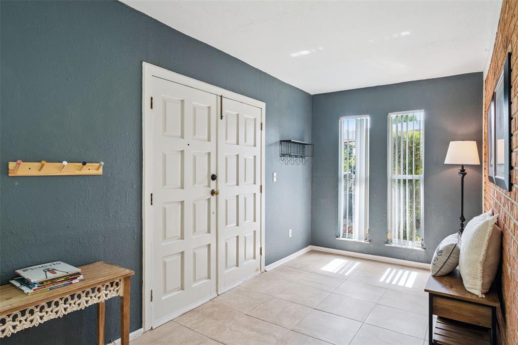 An entryway features a double door, gray walls, tile flooring, and a brick accent wall — 1504 IDAHO AVENUE, ORLANDO, FL