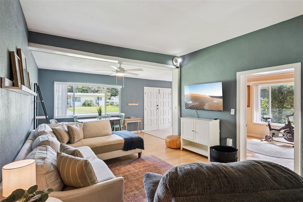 A living room features a sectional sofa, a wall-mounted television, and an adjacent exercise room — 1504 IDAHO AVENUE, ORLANDO, FL