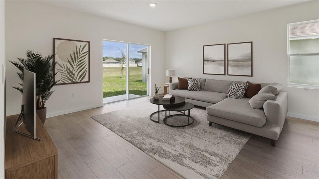 A living room features a grey sectional sofa, a nesting coffee table, and sliding glass doors — 1838 HOWARD MESA DRIVE, KISSIMMEE, FL