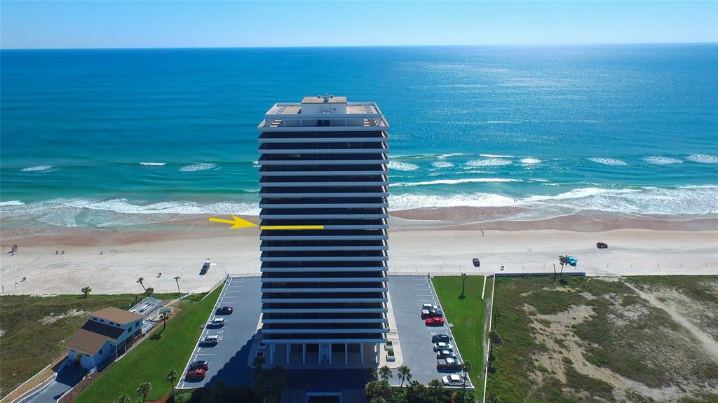 An aerial view shows a tall beachfront condominium building with a yellow arrow pointing toward it — 2200 N ATLANTIC AVENUE UNIT 1201, DAYTONA BEACH, FL