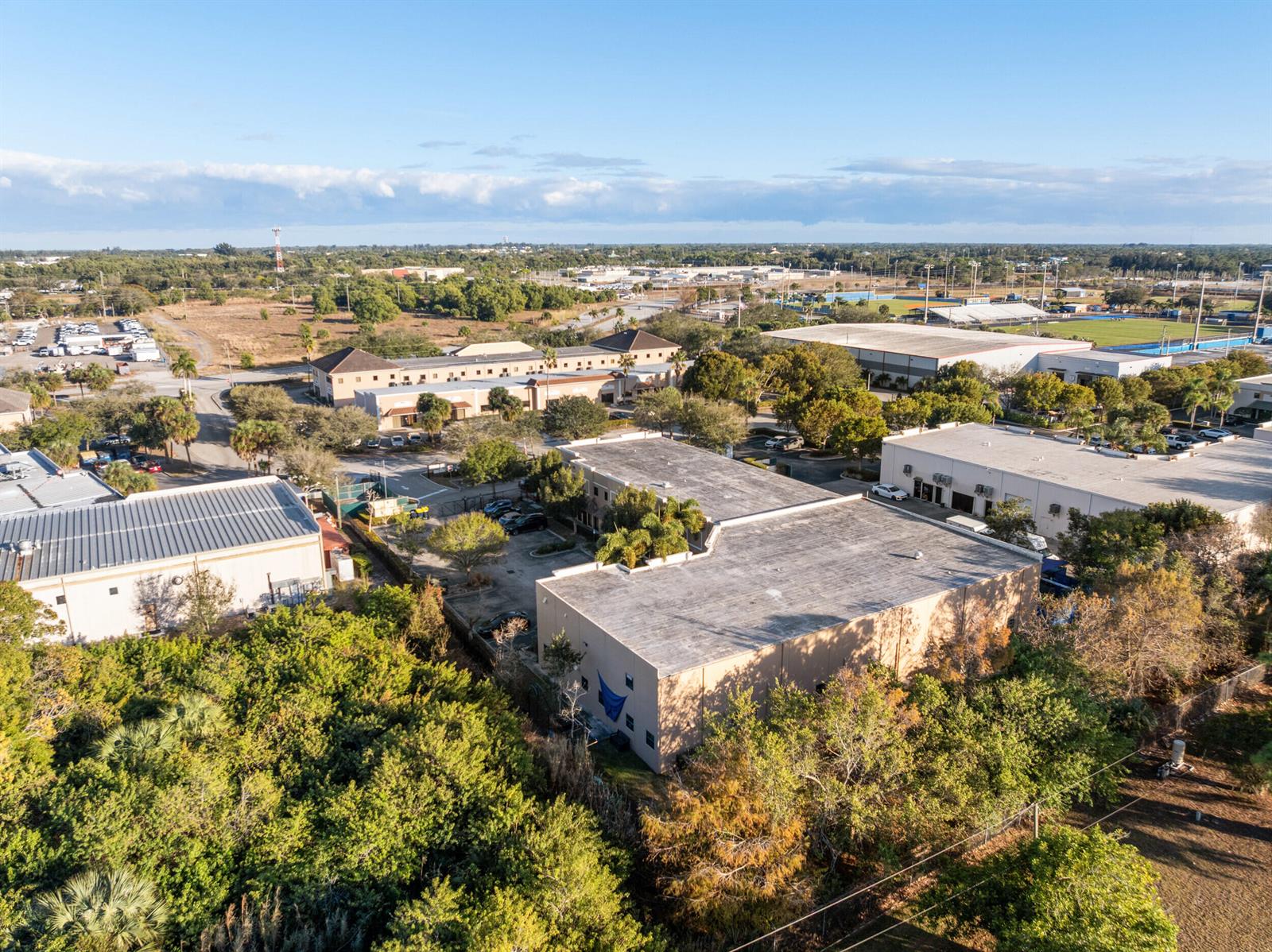 An aerial view shows several commercial buildings surrounded by trees and parking lots — 2580 SE Willoughby Boulevard, Stuart FL 34994, STUART, FL