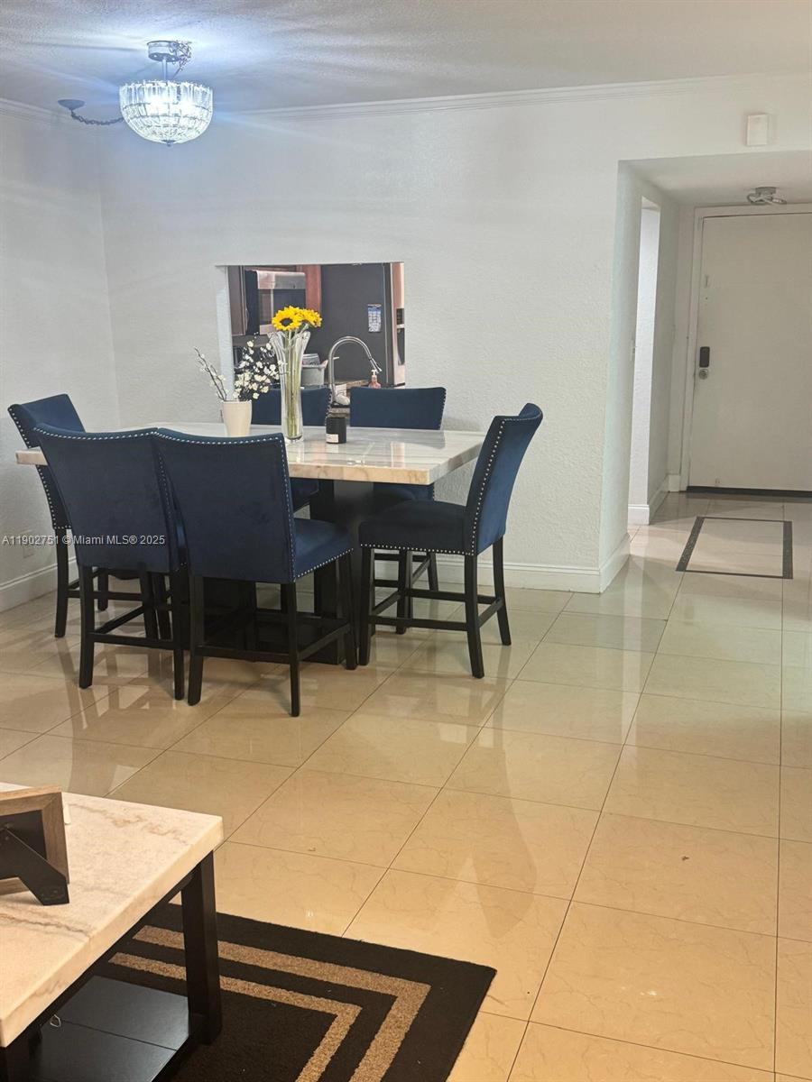 A dining area features a marble-topped table, blue upholstered chairs, and beige tile flooring — 3955 N Nob Hill Rd # 101, Sunrise FL 33351, SUNRISE, FL