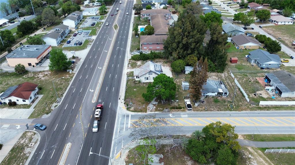 An aerial view shows a multi-lane road intersecting with a street near residential buildings — 980 S LAKE SHORE WAY, LAKE ALFRED, FL