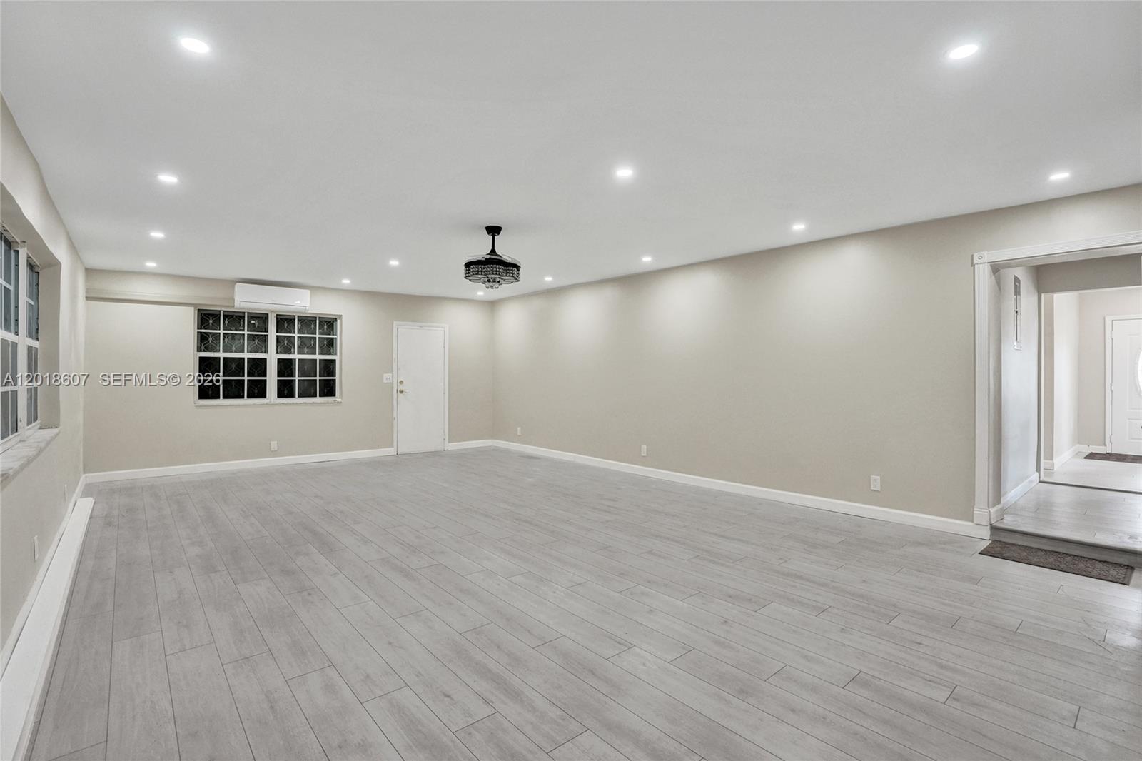 A spacious, empty room features light gray wood-look flooring, recessed lighting, and a ceiling fan — 3401 NW 7th St, Lauderhill FL 33311, LAUDERHILL, FL