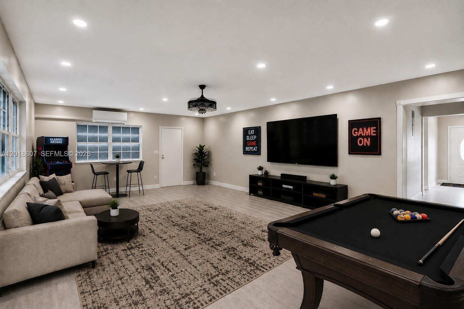 A game room features a pool table, sectional sofa, large television, and arcade cabinet — 3401 NW 7th St, Lauderhill FL 33311, LAUDERHILL, FL