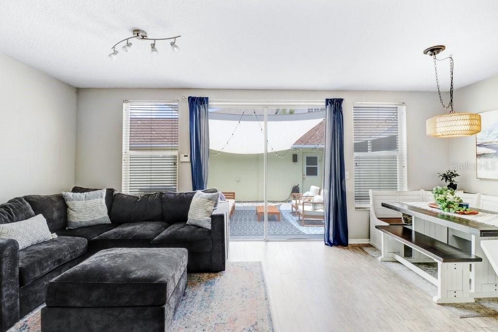 A living and dining area with a sectional sofa, dining table, and sliding glass doors — 9915 NEW PARKE ROAD, TAMPA, FL
