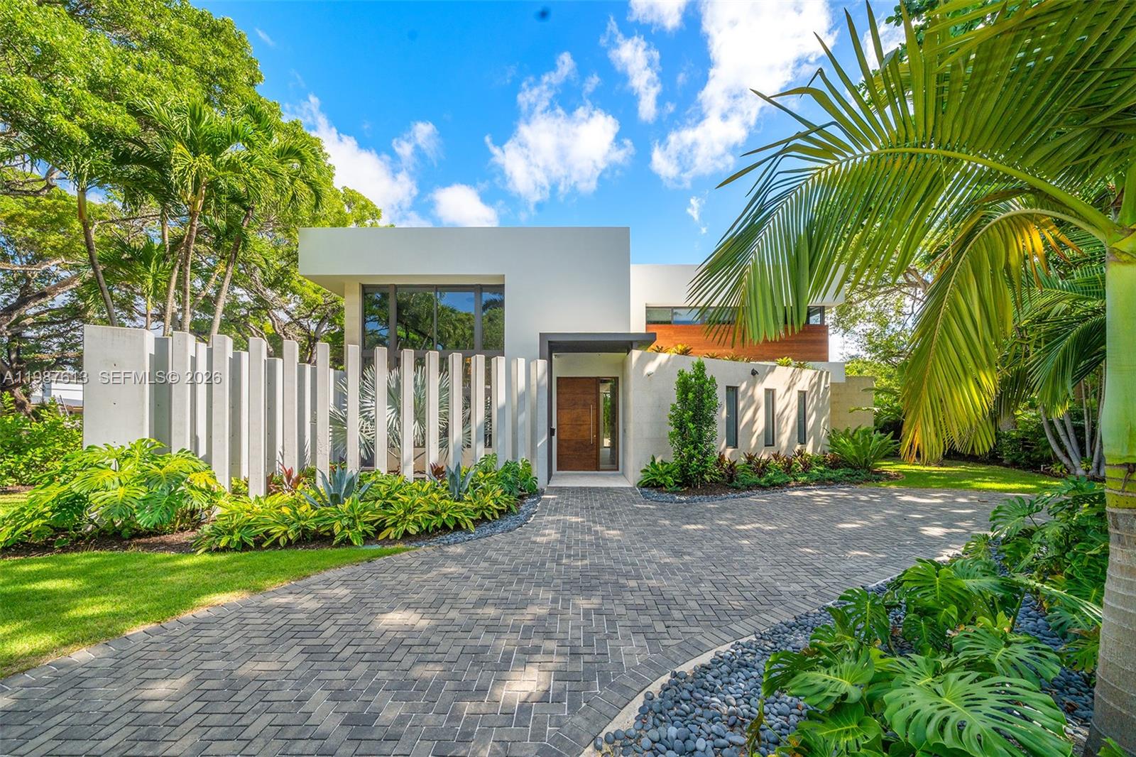 A modern house with a white facade, vertical concrete slats, and a paved driveway — 4041 S Le Jeune Rd, Miami FL 33146, MIAMI, FL