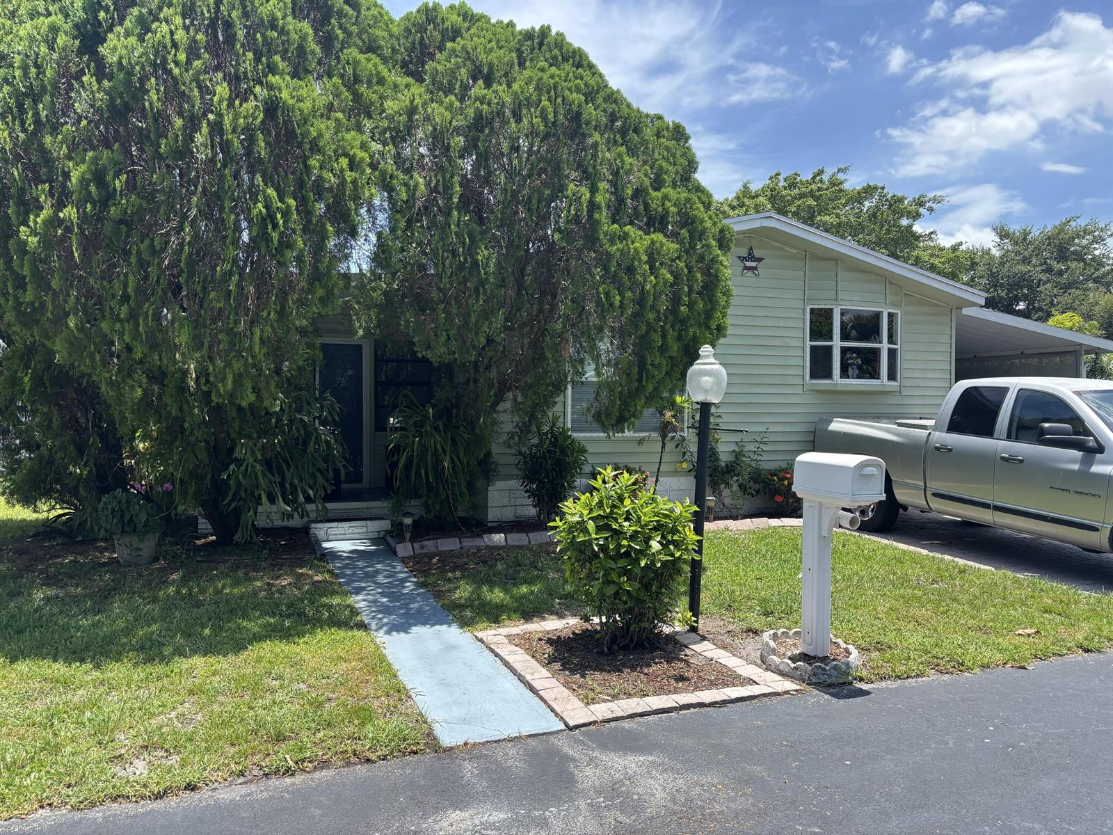 A light green house with a large tree, a paved walkway, and a white mailbox — 4520 NW 68th Place, Coconut Creek FL 33073, COCONUT CREEK, FL