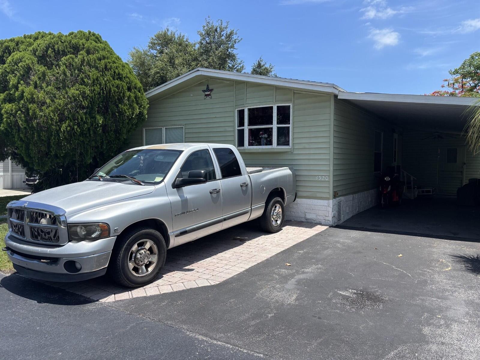 A silver pickup truck is parked in the driveway of a light green mobile home — 4520 NW 68th Place, Coconut Creek FL 33073, COCONUT CREEK, FL