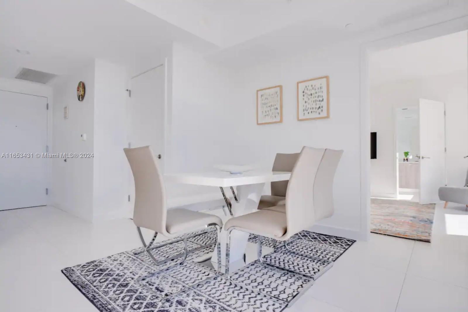 A dining area features a white table, four chairs, and a patterned rug on tile floors — 501 NE 31st St # 3709, Miami FL 33137, MIAMI, FL