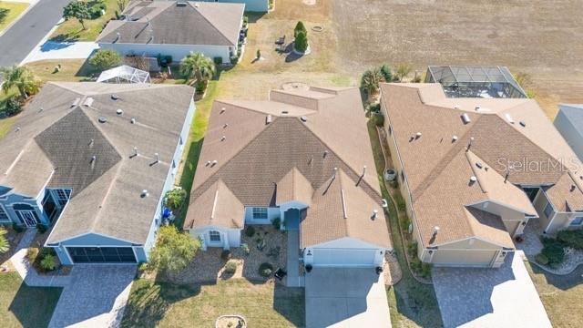 An aerial view shows three suburban houses with brown roofs and paved driveways — 1338 SW 161ST PLACE, OCALA, FL
