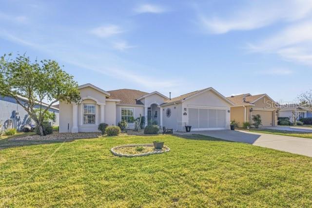 A single-story suburban house with a light-colored exterior, a two-car garage, and a front lawn — 1338 SW 161ST PLACE, OCALA, FL