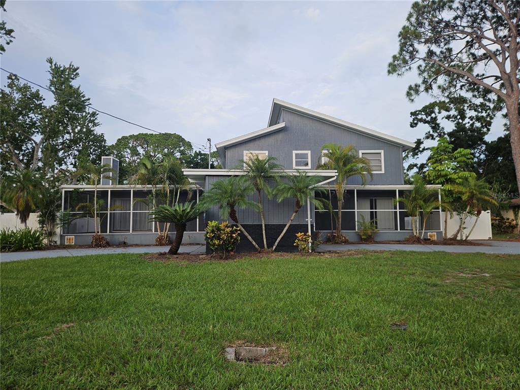 A two-story blue house with a screened-in porch and palm trees in the front yard — 2321 INGRAM AVENUE, SARASOTA, FL