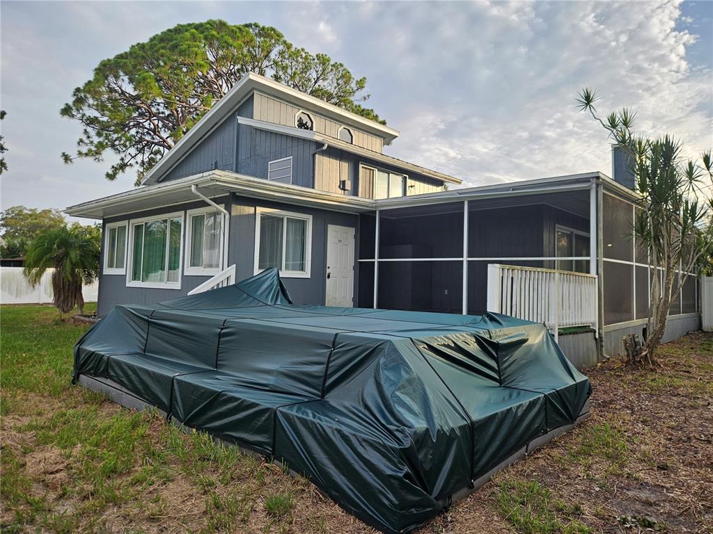 A blue house with a screened-in porch and a covered pool in the backyard — 2321 INGRAM AVENUE, SARASOTA, FL