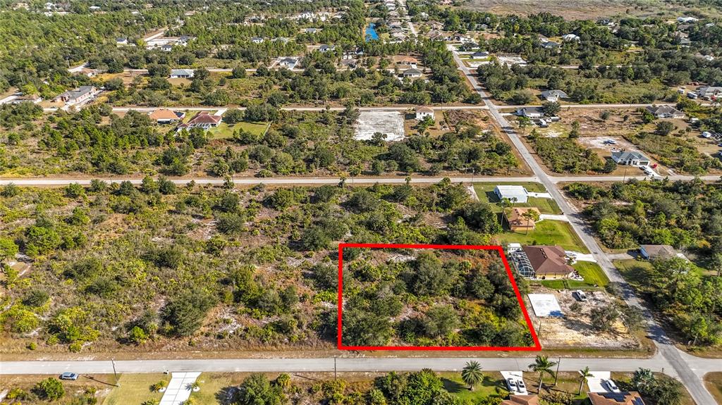 An aerial view shows a rectangular, undeveloped lot outlined in red within a residential area — 904 LAKE AVENUE, LEHIGH ACRES, FL