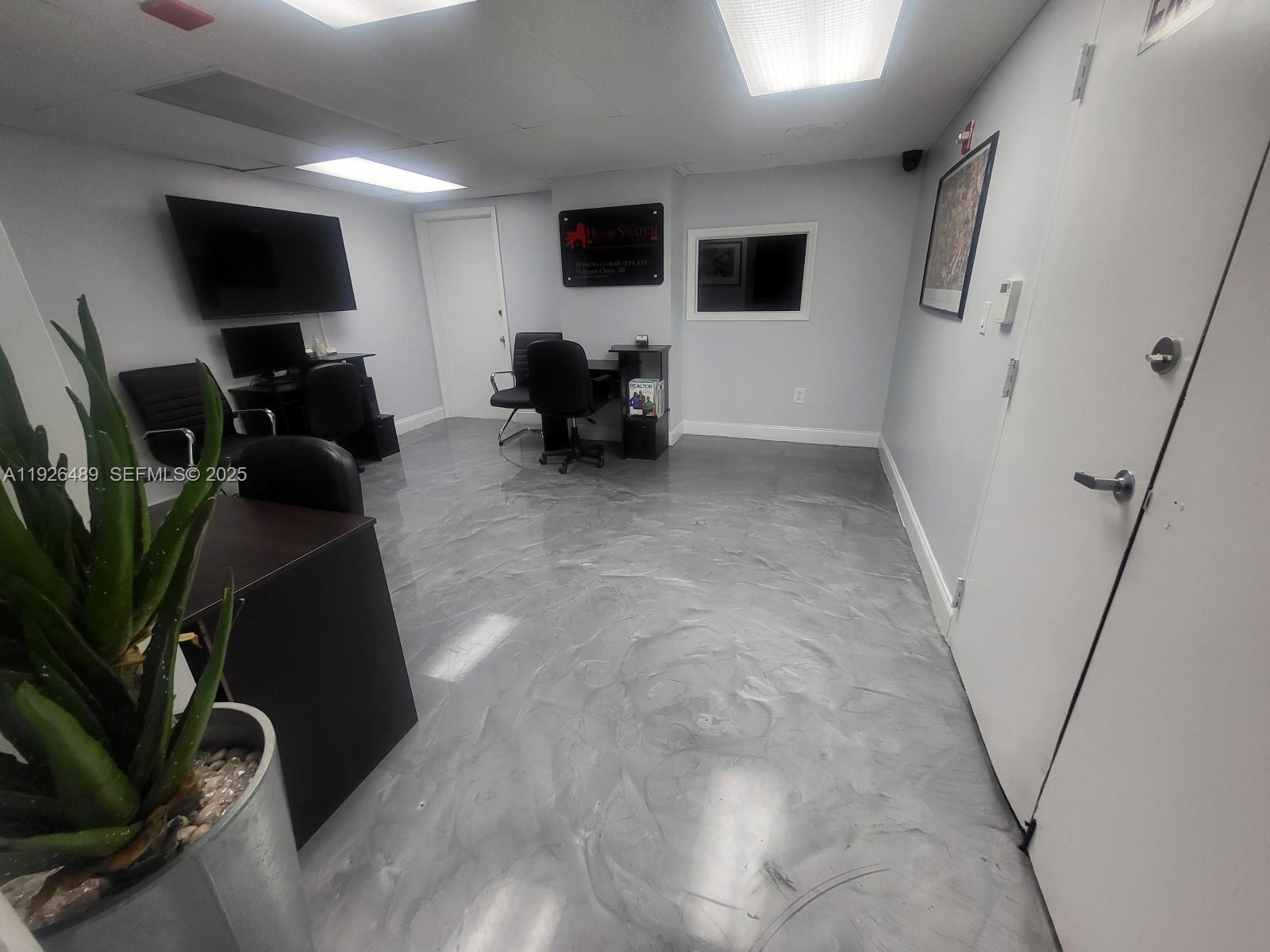 An office space features a gray marbled epoxy floor, two desks, and a potted plant — 13499 Biscayne Blvd, North Miami FL 33181, NORTH MIAMI, FL
