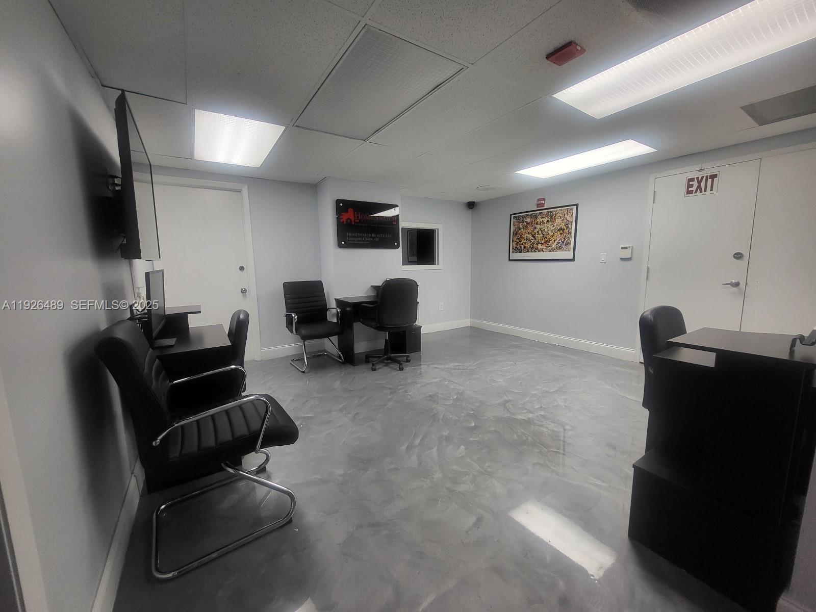 An office space features a gray epoxy floor, black furniture, and white walls — 13499 Biscayne Blvd, North Miami FL 33181, NORTH MIAMI, FL