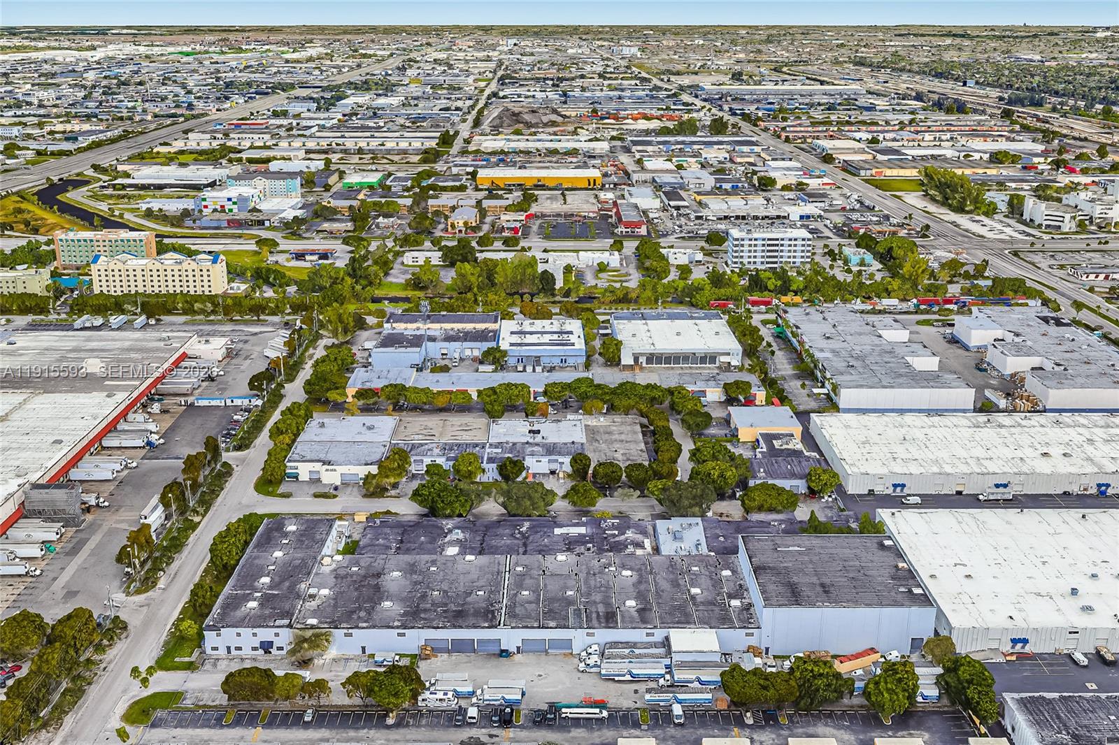 An aerial view shows a large industrial complex with flat-roofed warehouses and surrounding parking lots — 3353 NW 74th Ave, Miami FL 33122, MIAMI, FL
