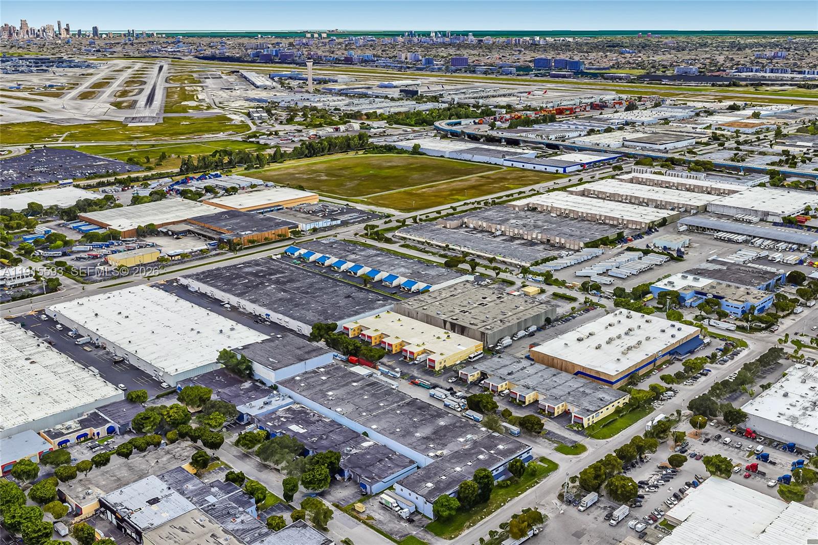 An aerial view shows industrial warehouse buildings and parking lots near an airport runway — 3353 NW 74th Ave, Miami FL 33122, MIAMI, FL