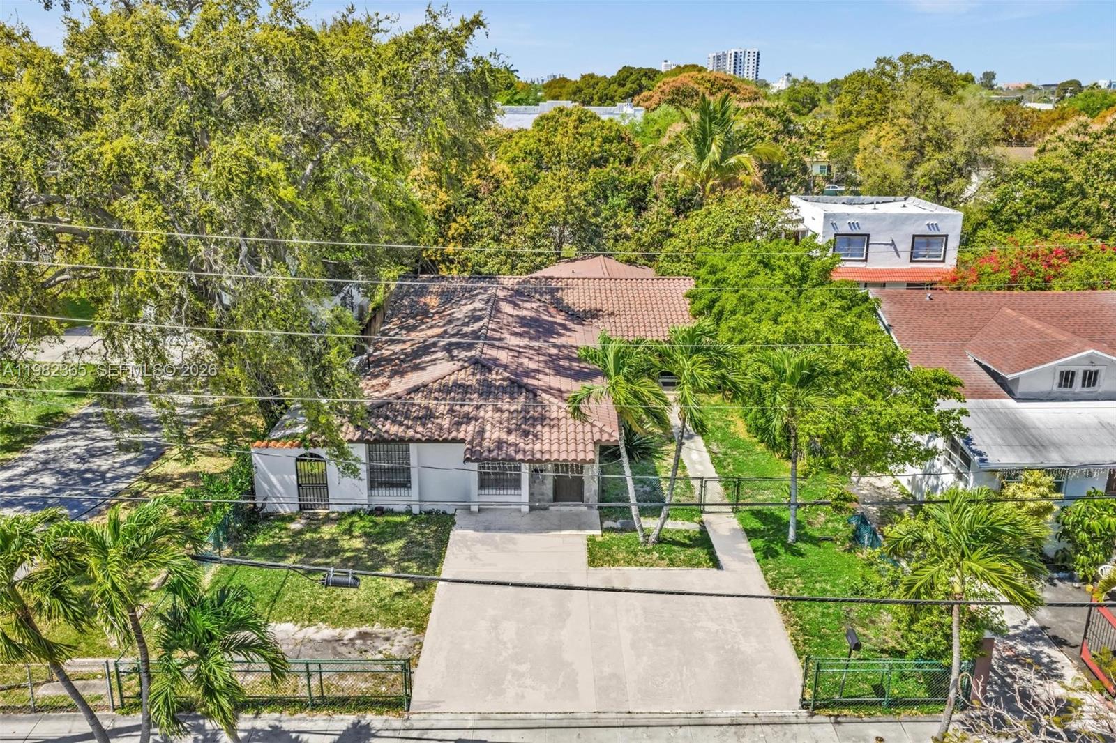 An aerial view shows a single-story house with a tiled roof and a concrete driveway — 1010 SW 14th Ave, Miami FL 33135, MIAMI, FL