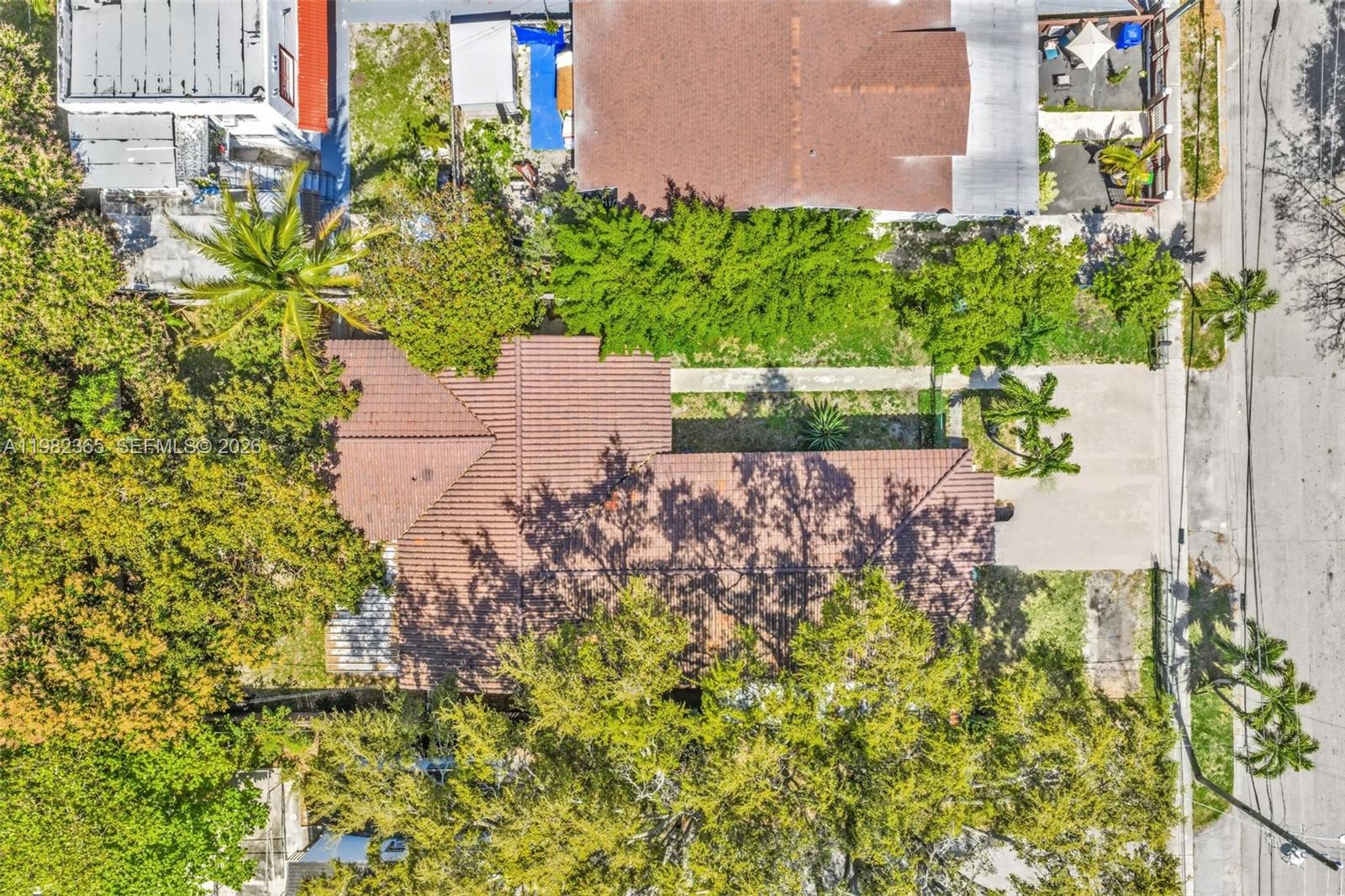 An aerial view shows a house with a brown tile roof surrounded by lush trees — 1010 SW 14th Ave, Miami FL 33135, MIAMI, FL