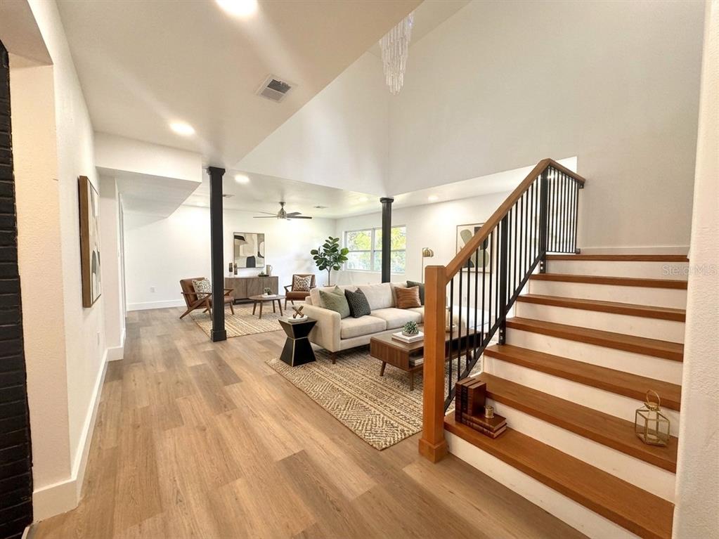 A kitchen and dining area with white cabinets, a slatted island, and dark ceiling beams — 14 GLENDALE DRIVE, KISSIMMEE, FL