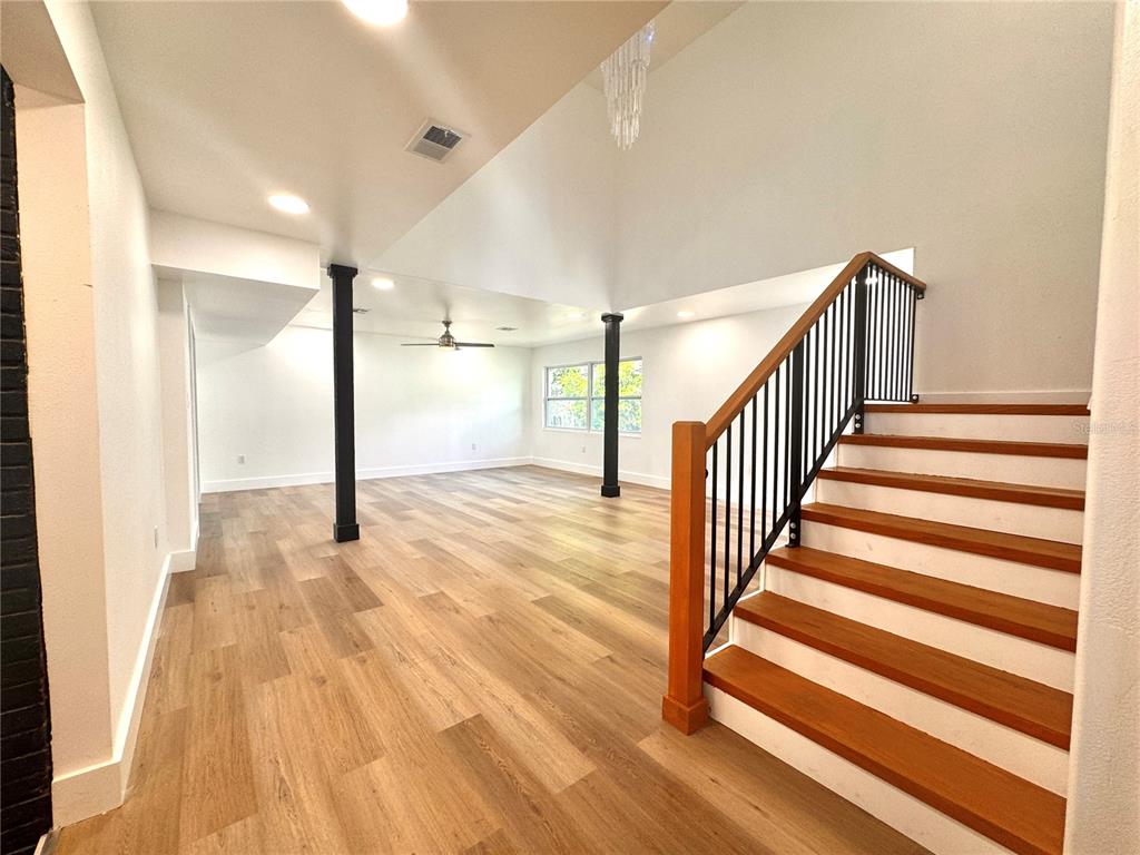 A kitchen features white cabinetry, a large island, stainless steel appliances, and a brick wall — 14 GLENDALE DRIVE, KISSIMMEE, FL