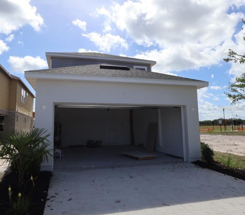 A modern kitchen features white cabinets, stainless steel appliances, a center island, and wood flooring — 5640 SAVANNA VALLEY TRAIL, ST CLOUD, FL