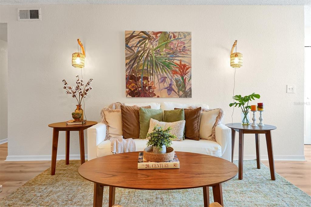 A living room features a white sofa, a wooden coffee table, and two side tables — 5156 CONROY ROAD UNIT 26, ORLANDO, FL