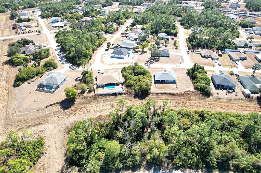 An aerial view shows a residential neighborhood with several houses, pools, and surrounding wooded areas — SEDBERRY AVENUE, NORTH PORT, FL