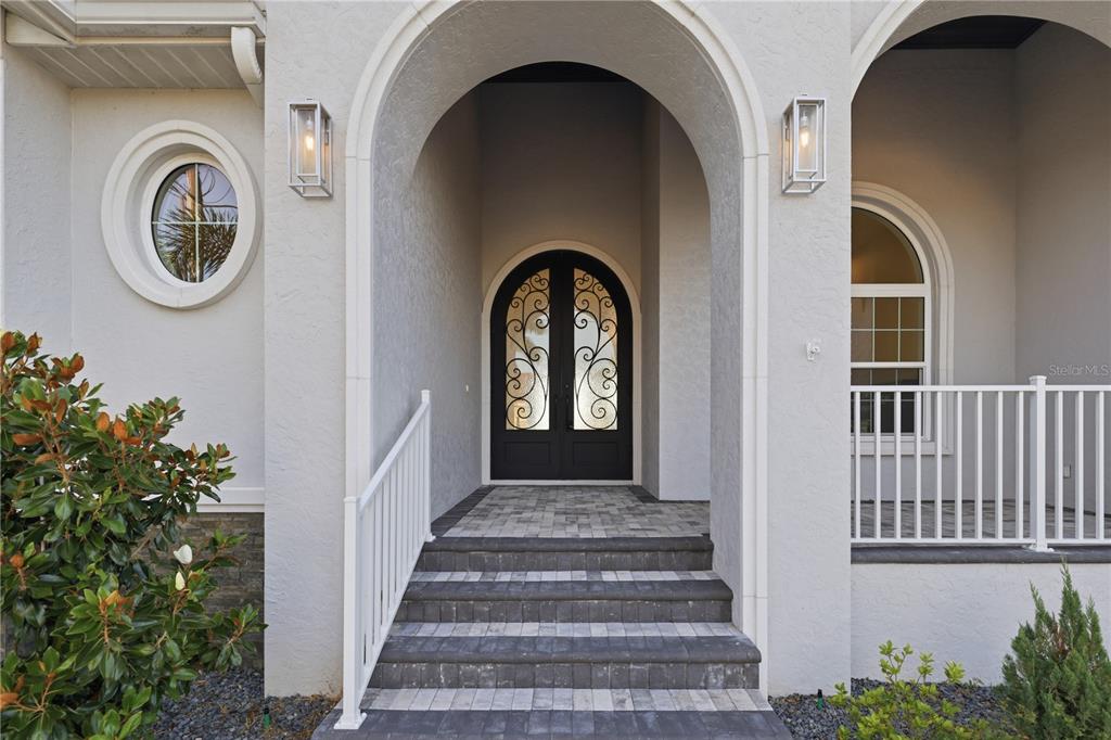 A front entrance features a double arched door, stone steps, and a white railing — 2139 PALM TREE DRIVE, PUNTA GORDA, FL